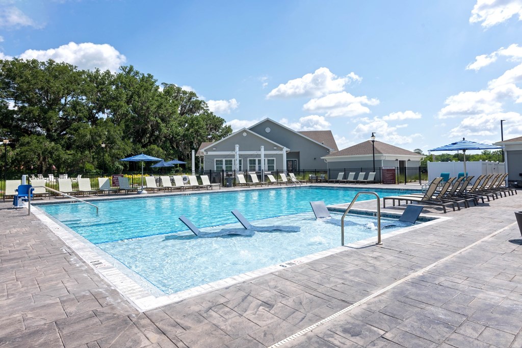 A large swimming pool with a building in the background.