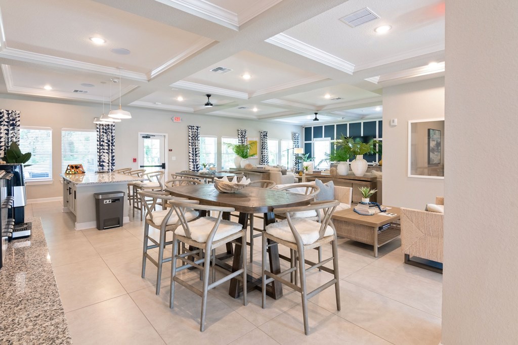 A dining room with a glass table surrounded by chairs.