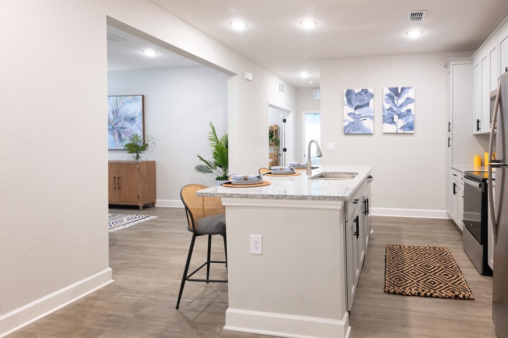 A kitchen with a white island and a chair.