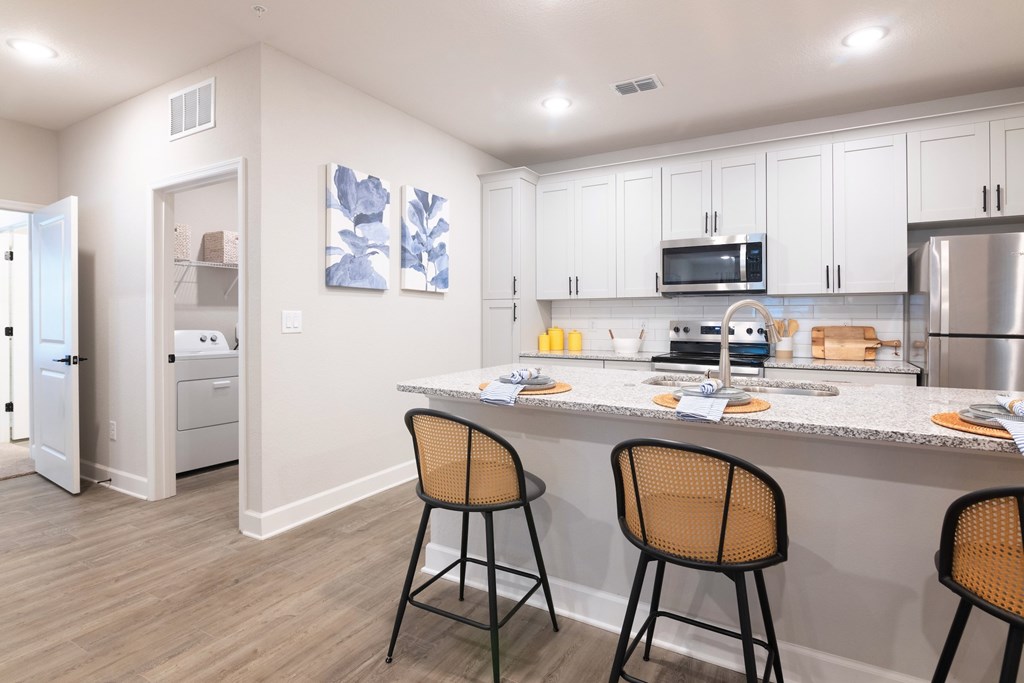 A kitchen with a white countertop and a white fridge.