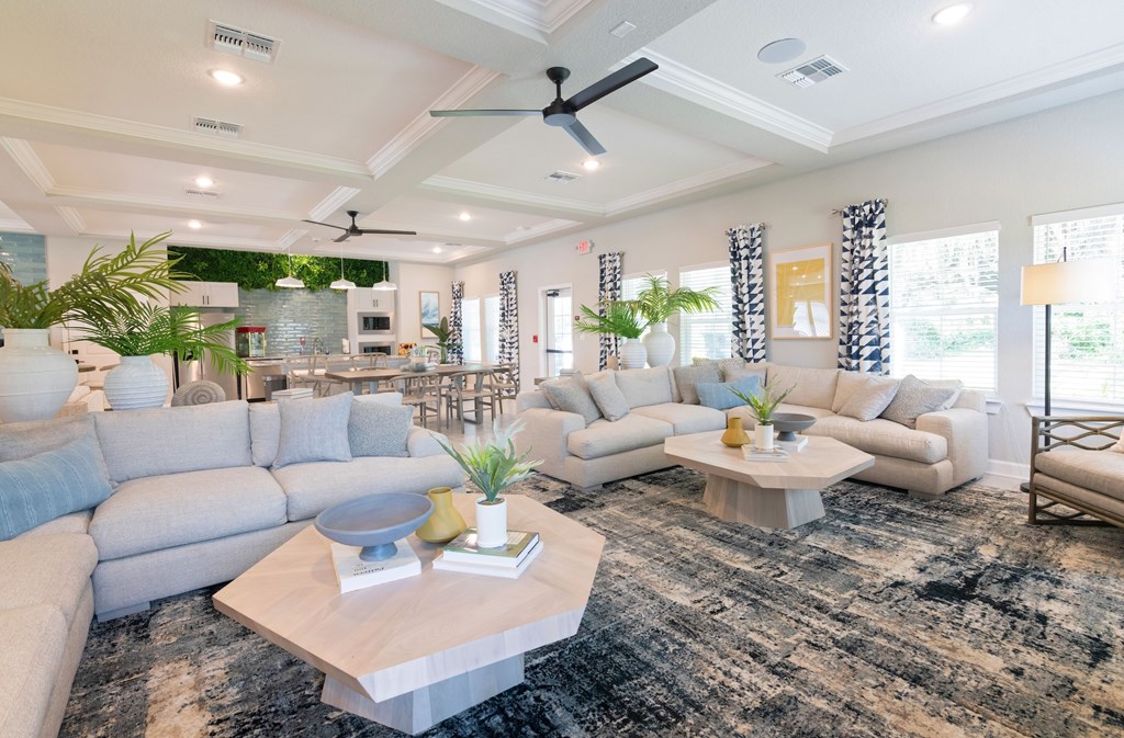 A spacious living room with a large sectional sofa, a coffee table, and a ceiling fan.