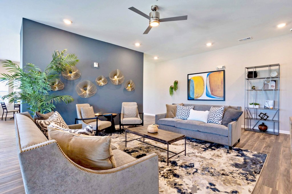 a living room with couches and chairs and a blue accent wall