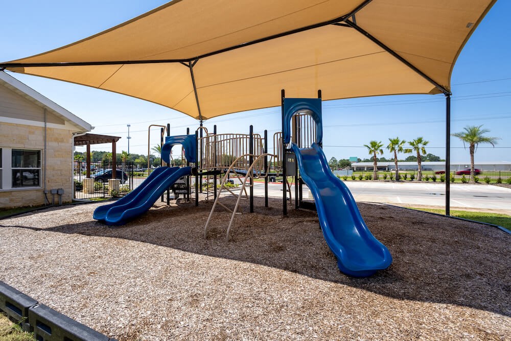 a playground with two slides and a swing set