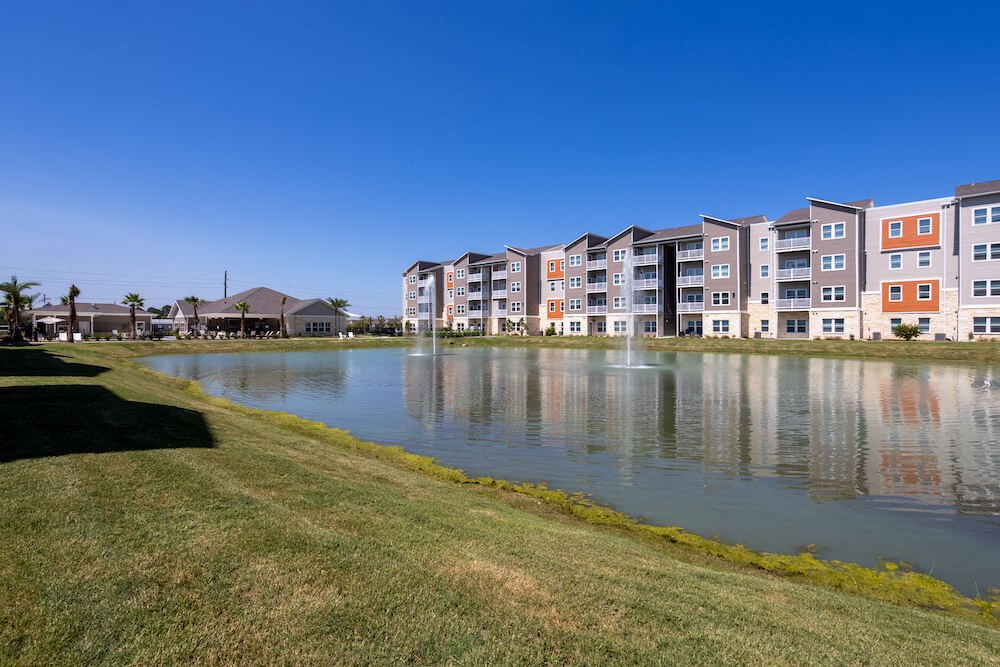 Pond in front of Promenade apartments with a clear blue sky
