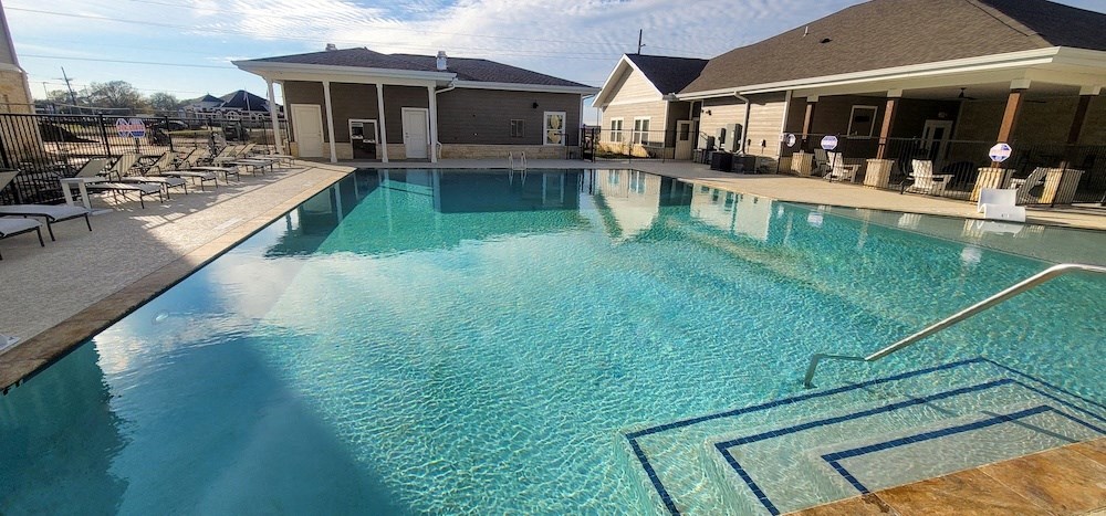 swimming pool with clubhouse in the background