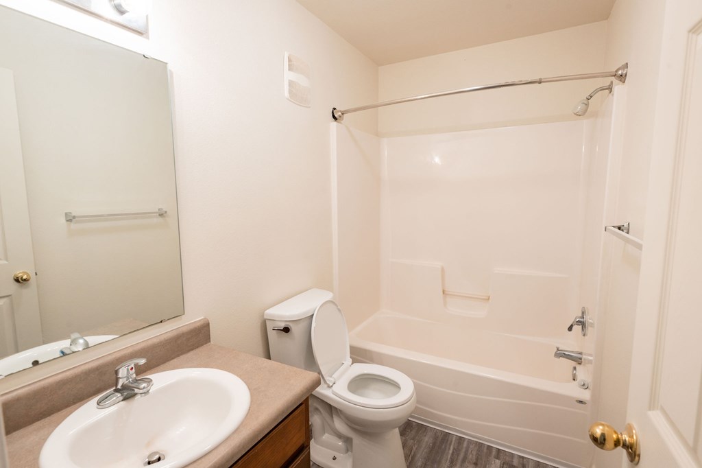 A bathroom with a toilet, sink, and bathtub.