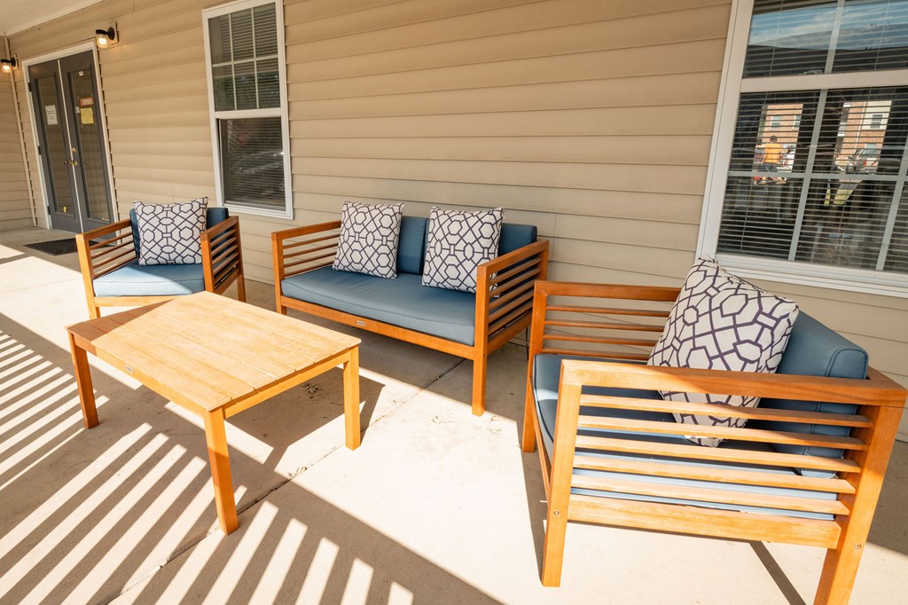 A wooden chair and table are on a patio.