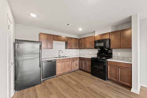 A kitchen with wooden cabinets and black appliances.