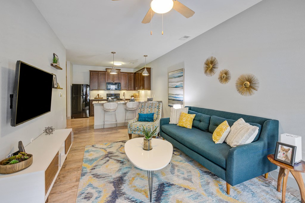 living room with a coffee table and couch with a kitchen in the background at The Vue Luxury apartments in Indianapolis