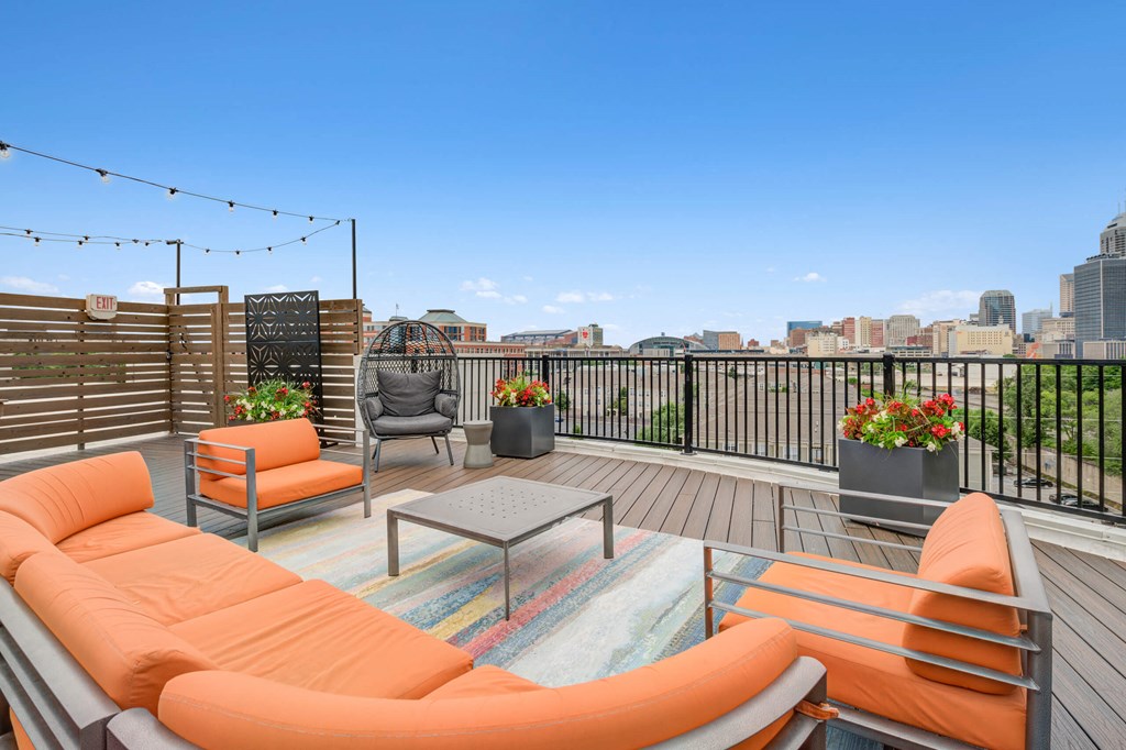 a rooftop deck with orange furniture overlooking Indianapolis