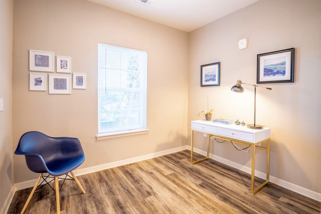 Apartment room with a desk, chair, and window at Trillium apartments