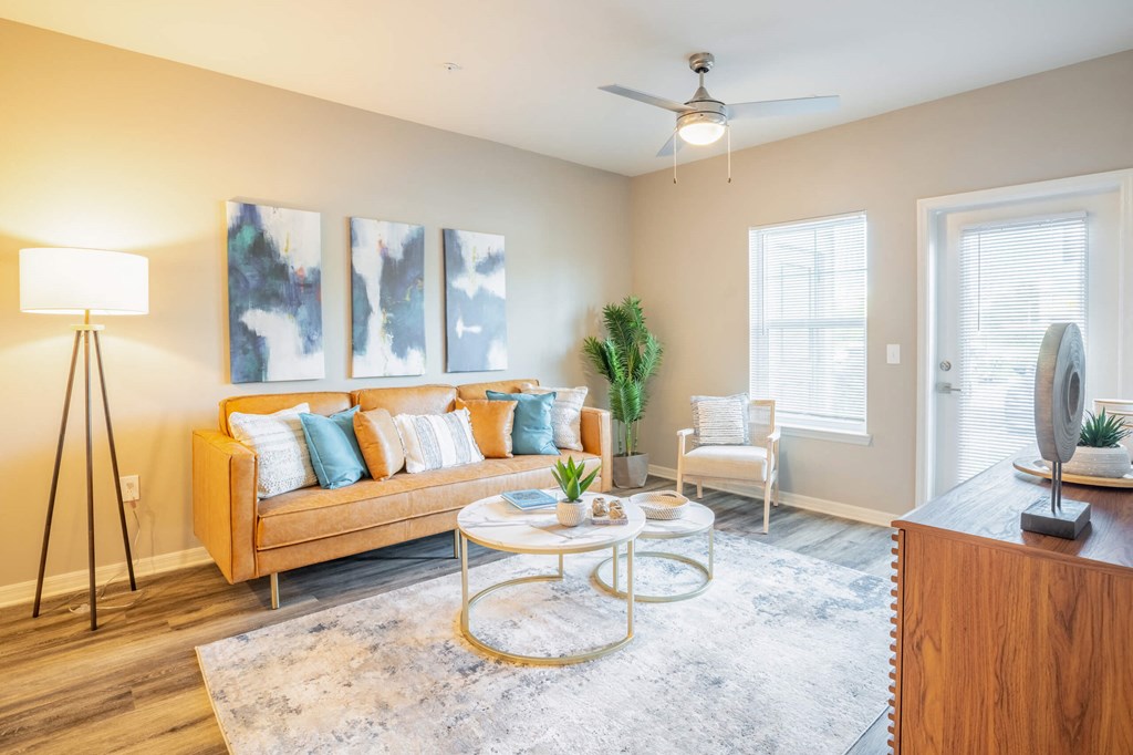 Living room with a couch, coffee table, a window and ceiling fan at Trillium apartments in Melbourne florida