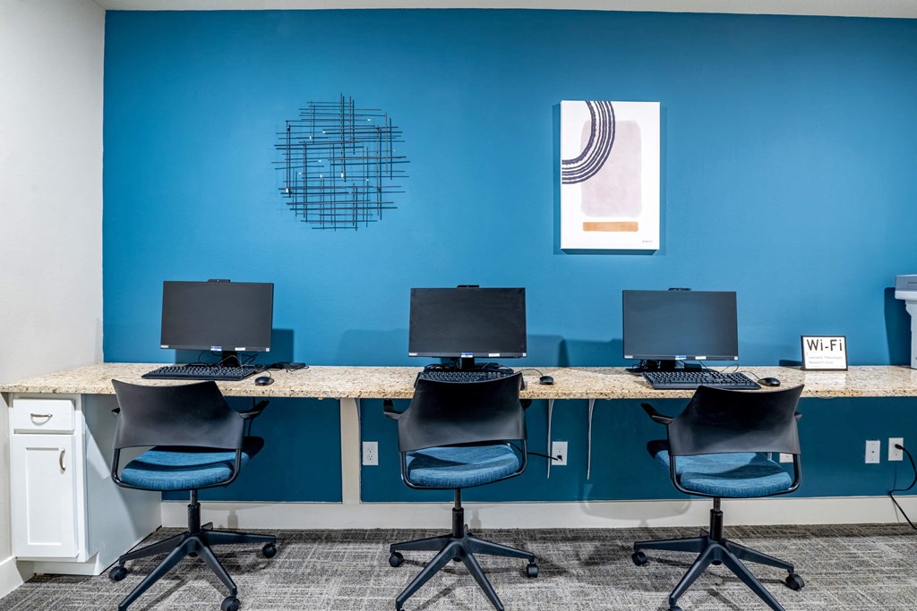 A row of three desktop computers and chairs at Trillium apartments in Melbourne fl