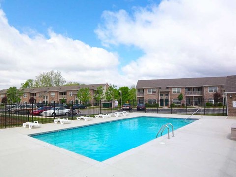 a swimming pool in front of canterbury house apartments