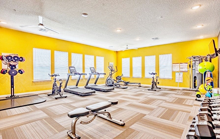 fitness center with cardio equipment and free weights at the flats at sundown apartments in north port florida