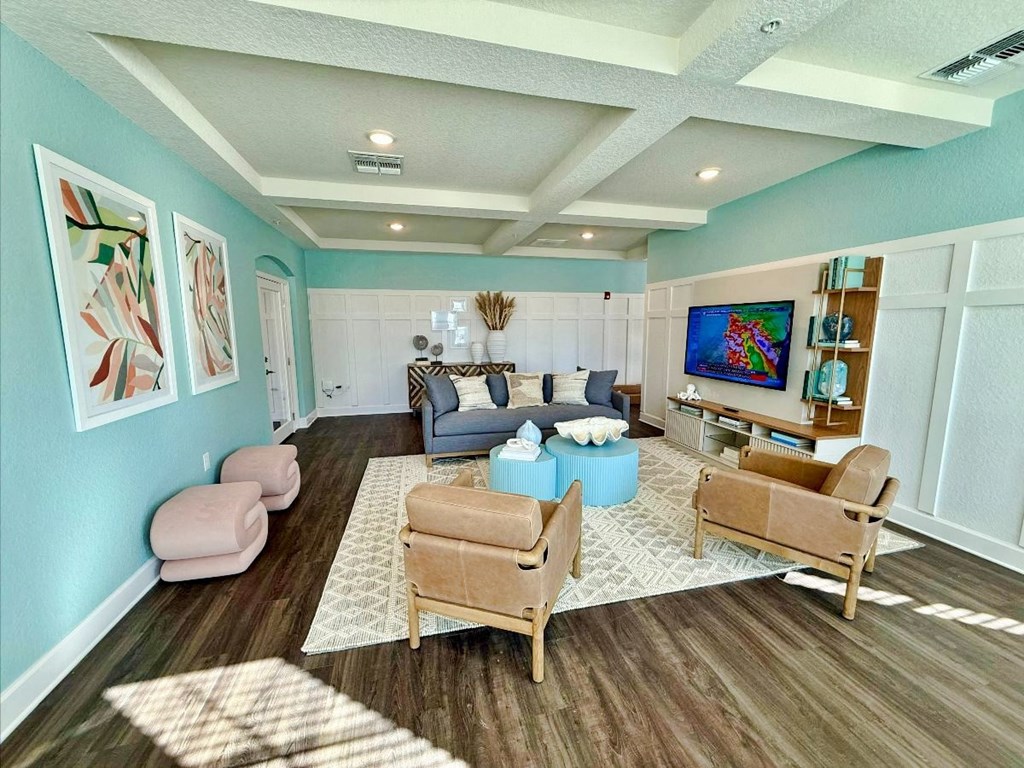 clubhouse living room a couch, chairs, and a tv at flats at sundown apartments in north port florida