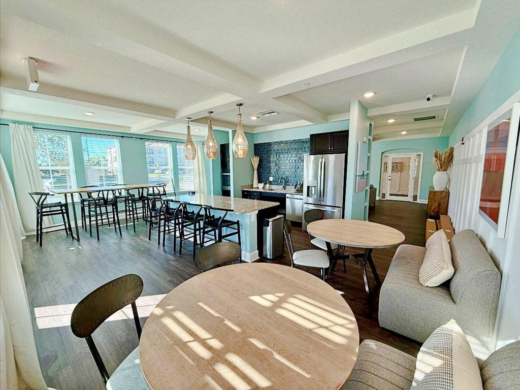 a community kitchen with a bar and kitchen appliances at flats at sundown apartments in north port florida