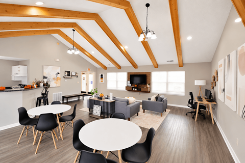 A modern open plan living and dining area with a kitchen in the background.