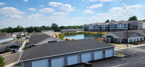 an aerial view of a building with a pond in the middle
