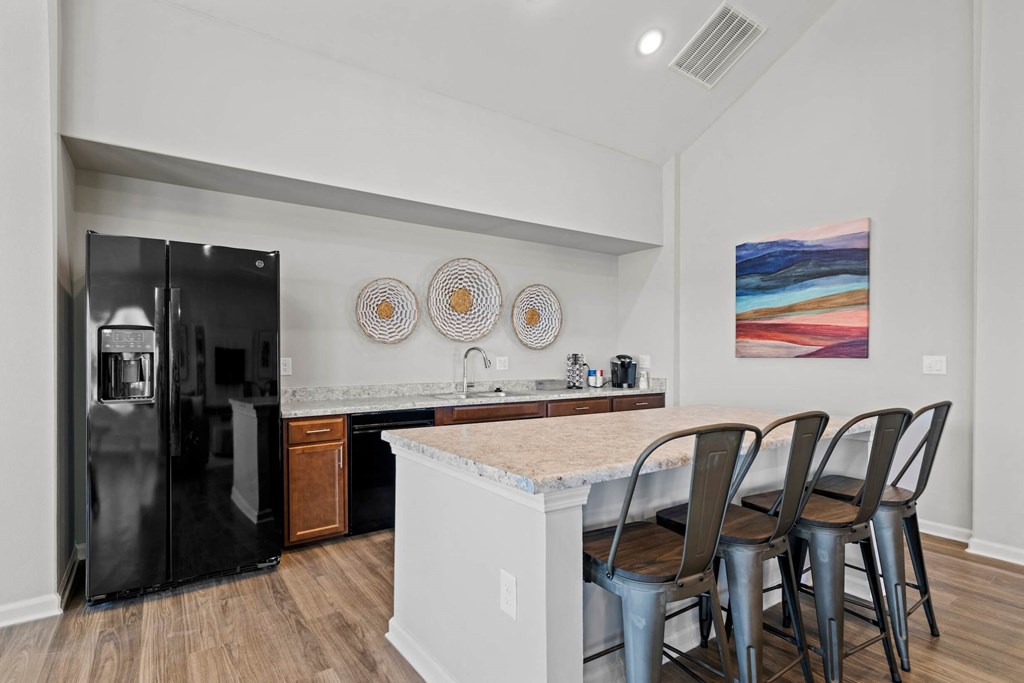 a kitchen with a bar and a refrigerator at legacy square senior apartments in san marcos tx
