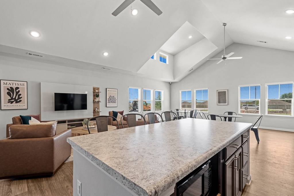 a large kitchen with a counter top and a living room with couches at legacy square senior apartments in san marcos tx