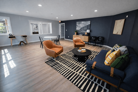A living room with a blue couch and a striped rug.