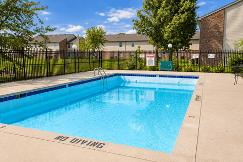 A pool with a black fence and a sign that says "No Diving".