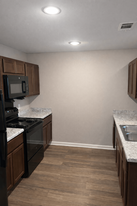 A kitchen with a black stove top oven and microwave.