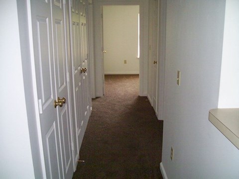 Hallway with white walls and a carpeted floor at Patriot Pointe Apartments in Liberty, IN