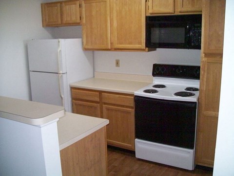 A white refrigerator sits next to a white counter in a kitchen.