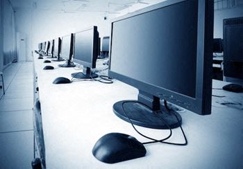 A row of computer monitors are lined up on a table.