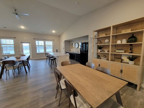 A dining room with a long wooden table and chairs.