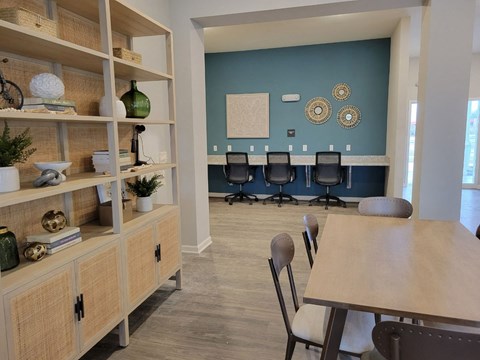 a community room with a table and chairs and a blue wall at Southern Meadows apartments