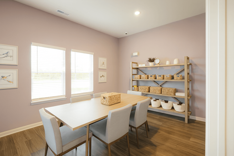 A dining room with a table and chairs.