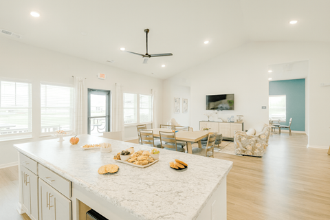 A kitchen with a white counter top and a ceiling fan.