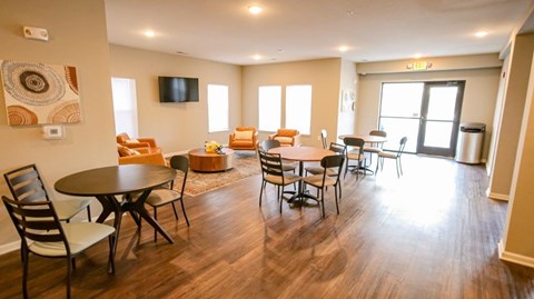 A living room with a TV, chairs, and a dining table.