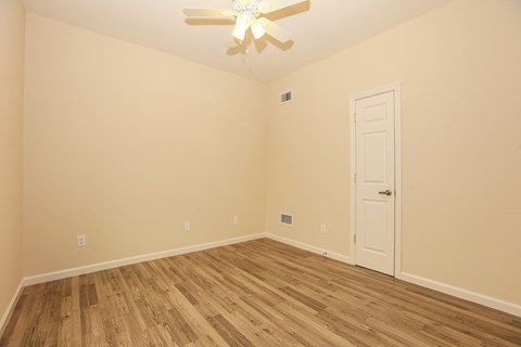 a bedroom with a ceiling fan and wood flooring