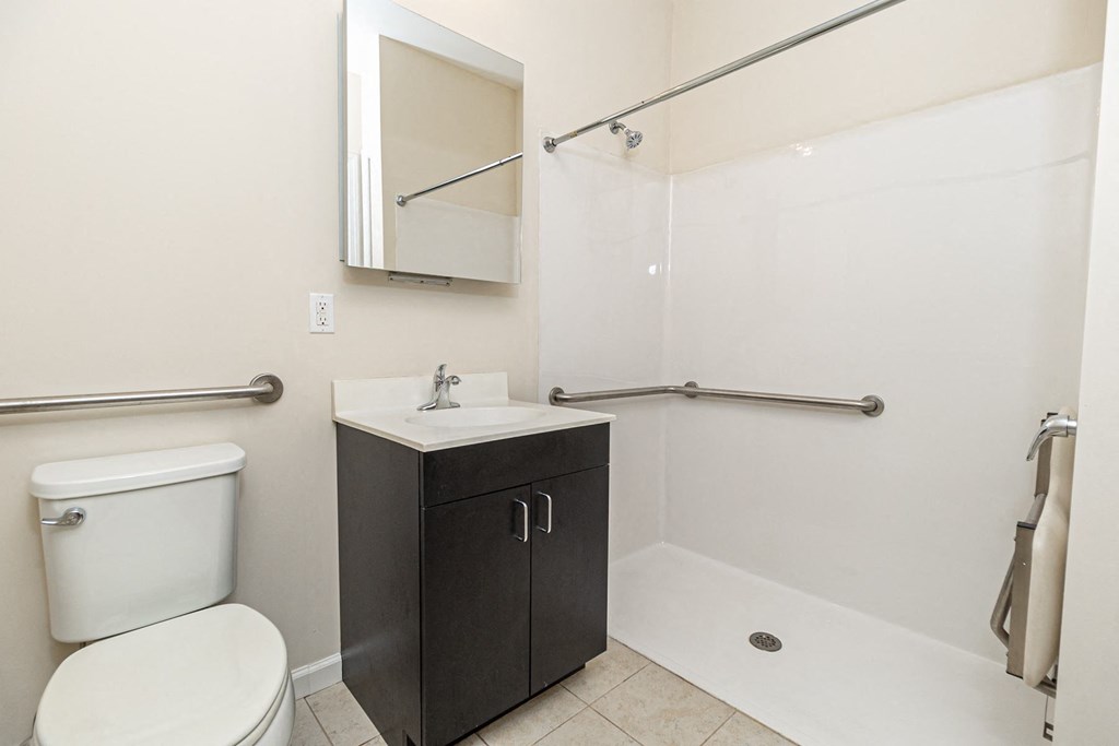 a bathroom with a toilet sink and shower and a mirror