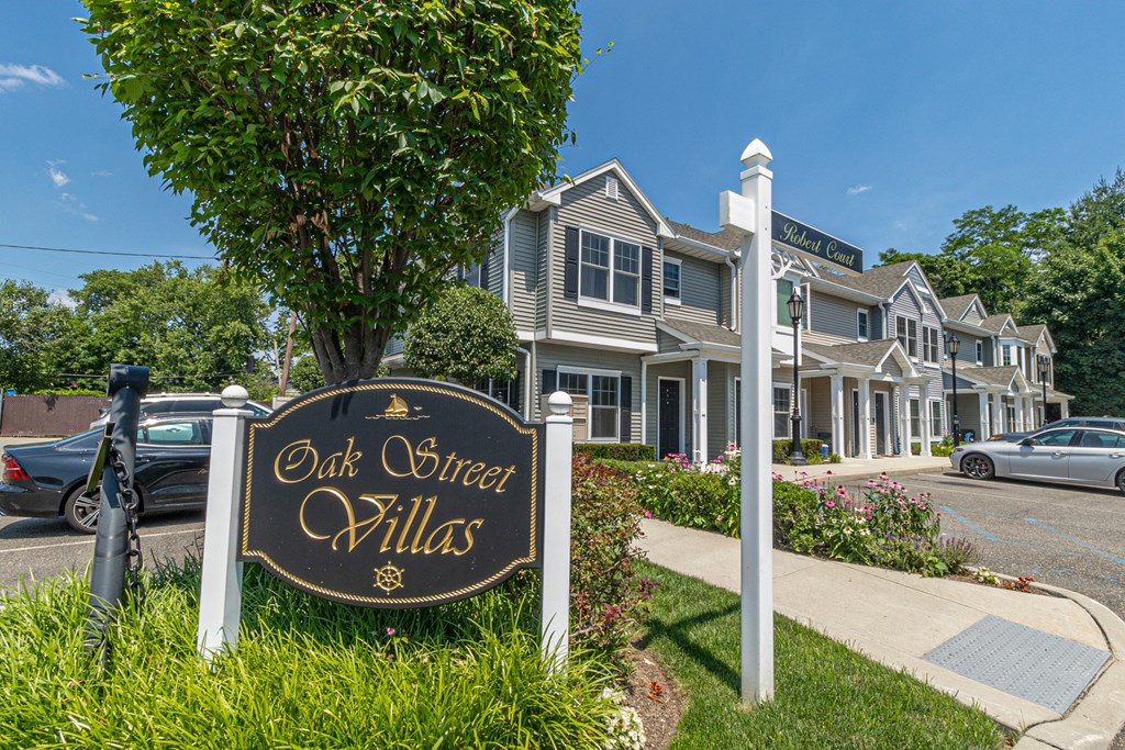 an old queen villas sign in front of a row of houses
