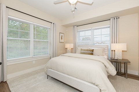A bedroom with a large bed and a ceiling fan.