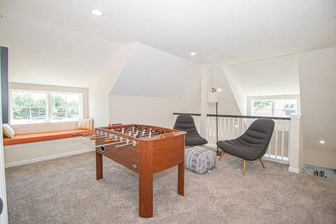 A room with a pool table and a chair.