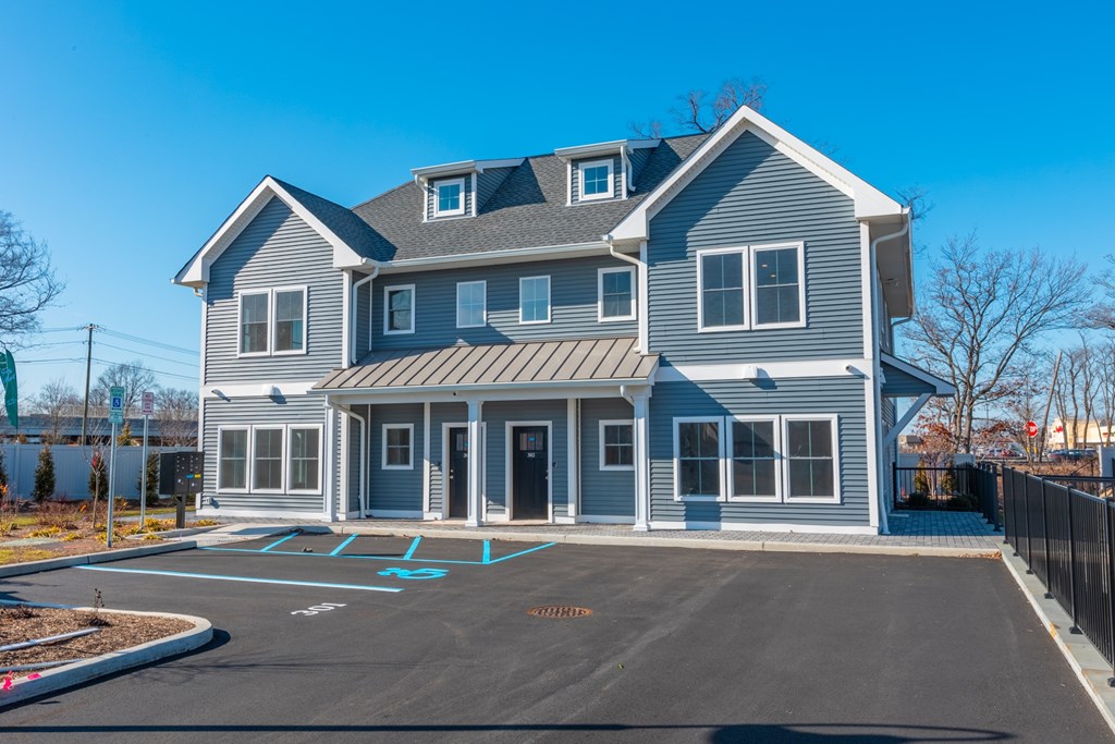 A large two-story house with a grey and white exterior and a black roof.