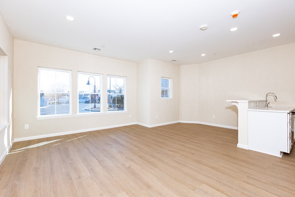 A large empty room with wooden floors and white walls.