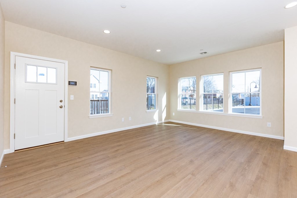 Empty room with white walls and wooden flooring.
