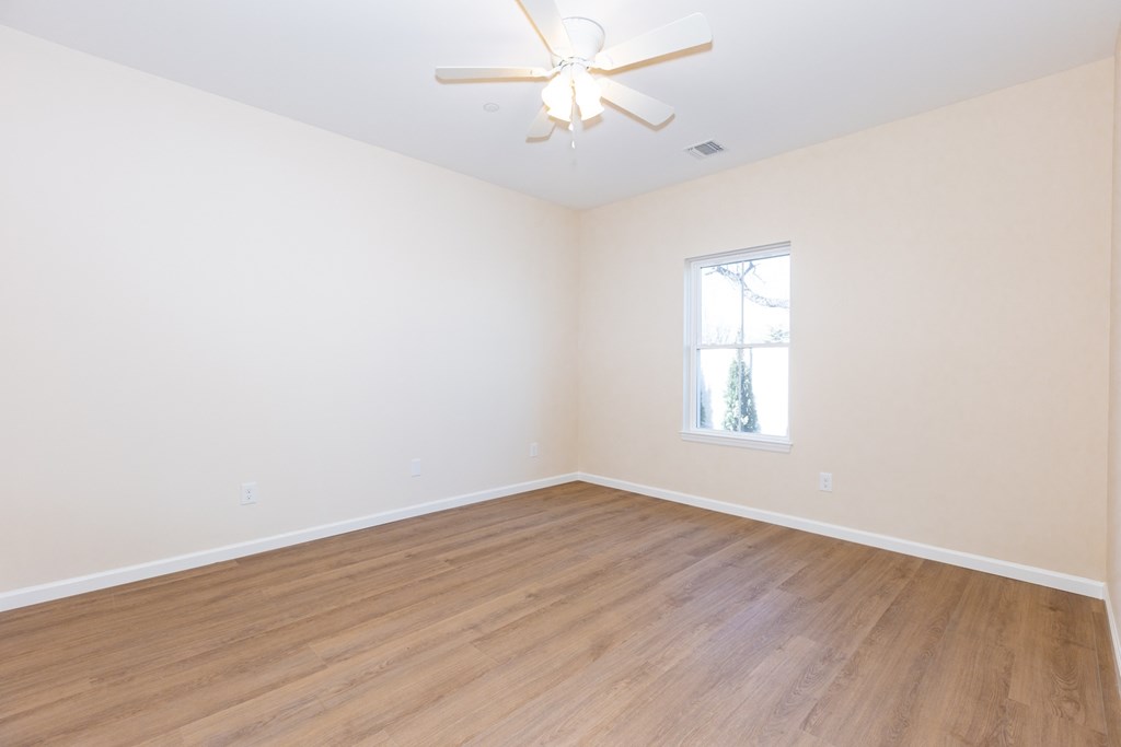 A room with a ceiling fan and a window.
