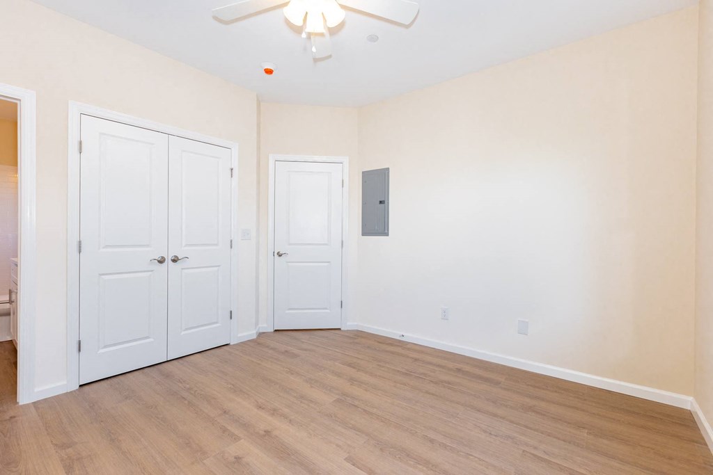 A room with a ceiling fan and two doors.