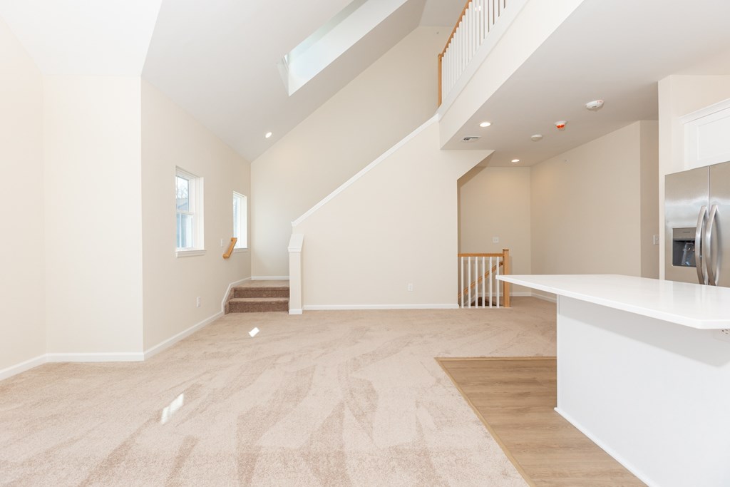 A spacious living room with a staircase leading to the upper floor.