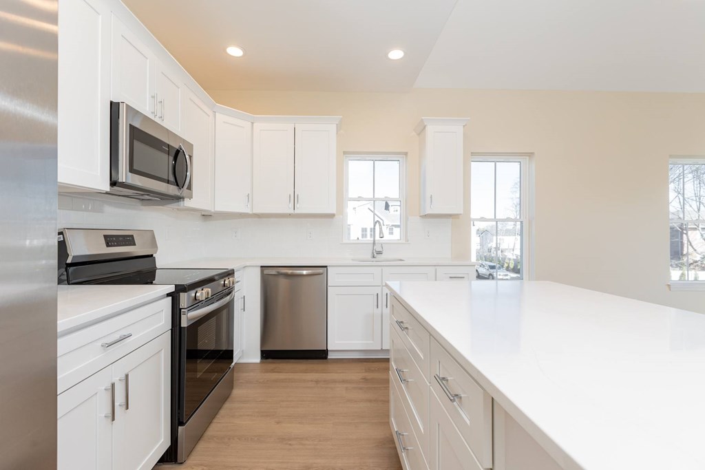 A kitchen with white cabinets and appliances.