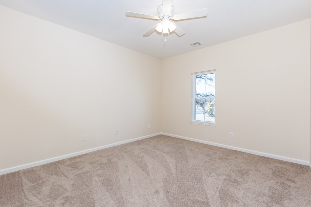 A room with a ceiling fan and a window.