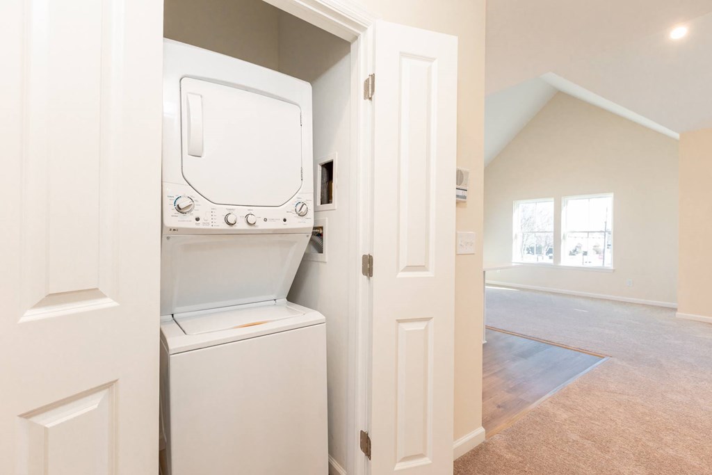 A white oven and dishwasher are in a kitchen with white walls.